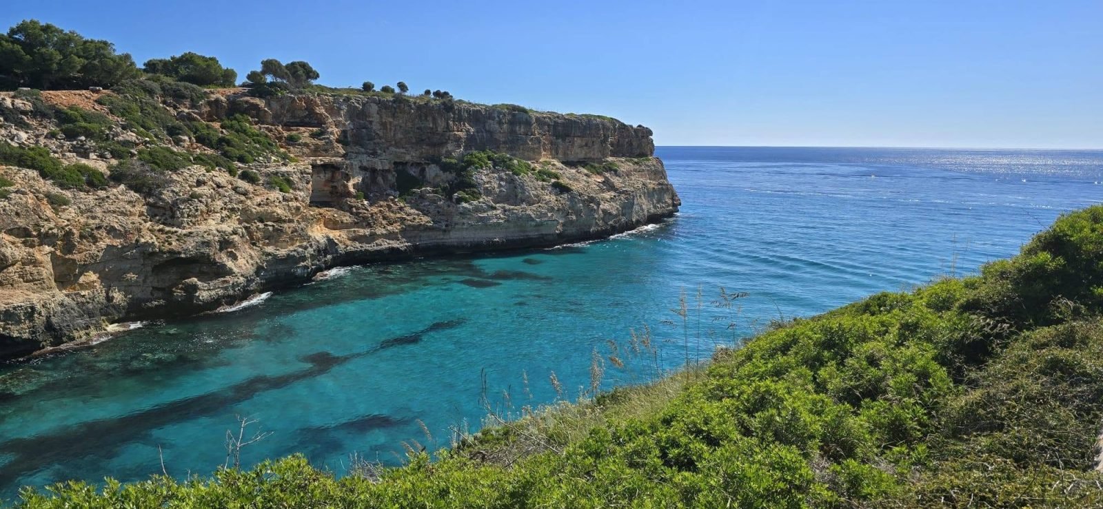Cala de aguas turquesa entre acantilados en la costa de Mallorca